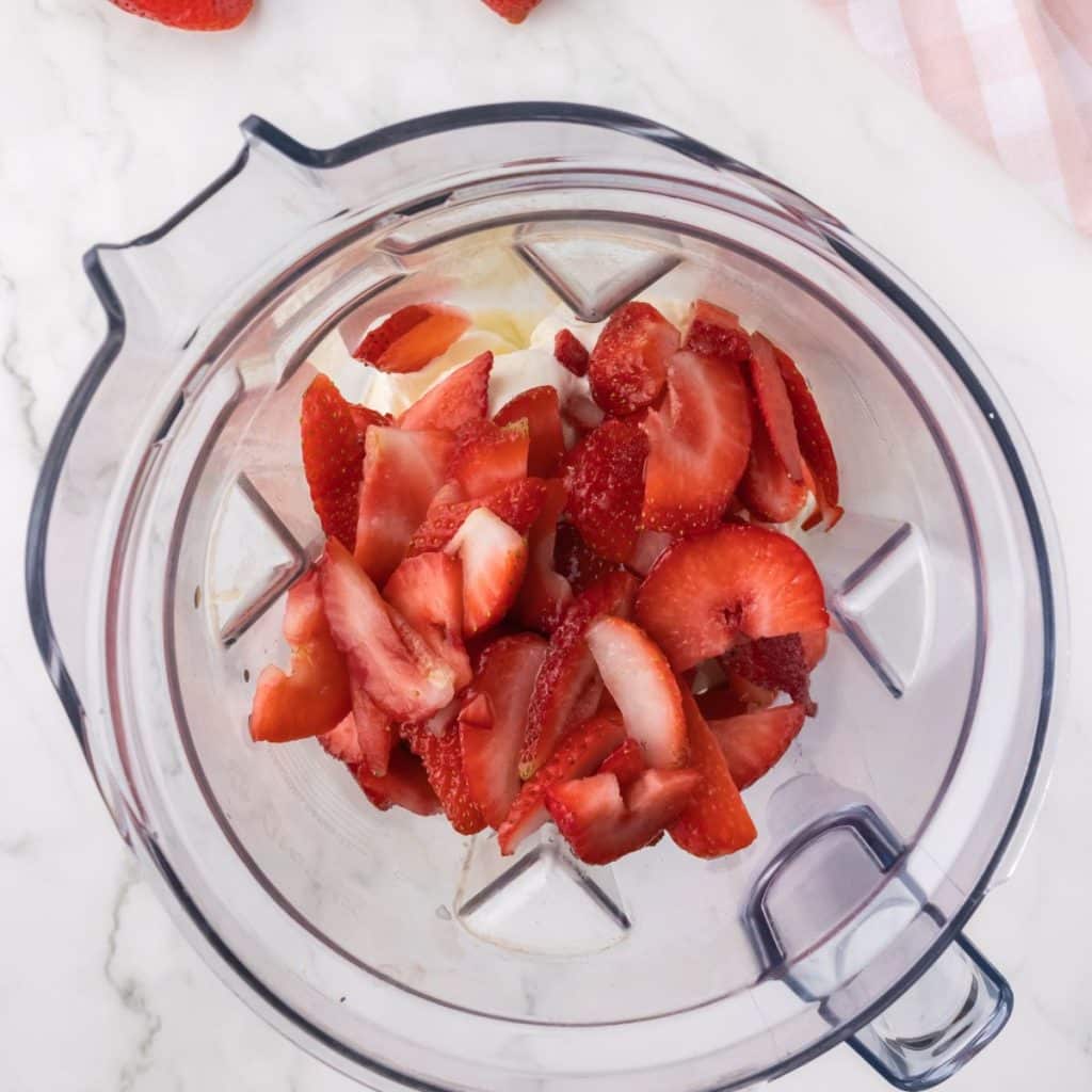 Blender with ice cream and fresh strawberries. 
