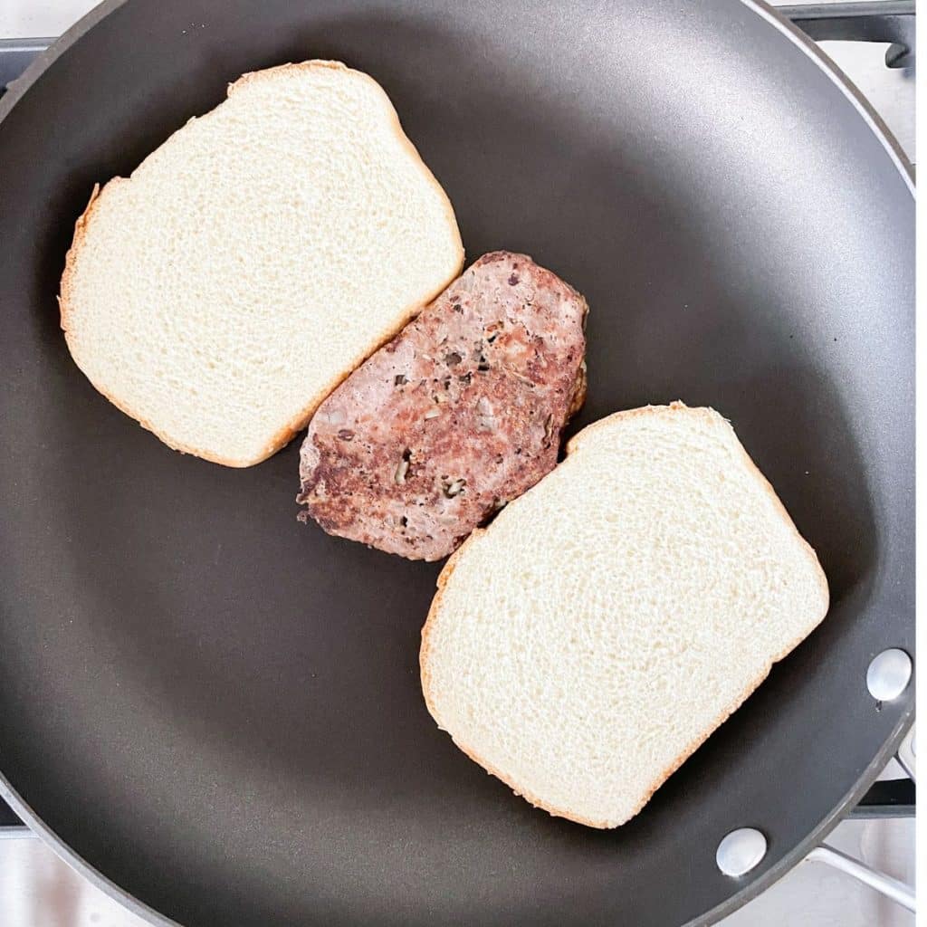 Bread and slice of meatloaf in a pan.