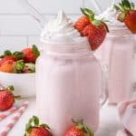 Glass with strawberry milkshake and whipped cream.