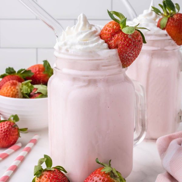 Glass with strawberry milkshake and whipped cream.