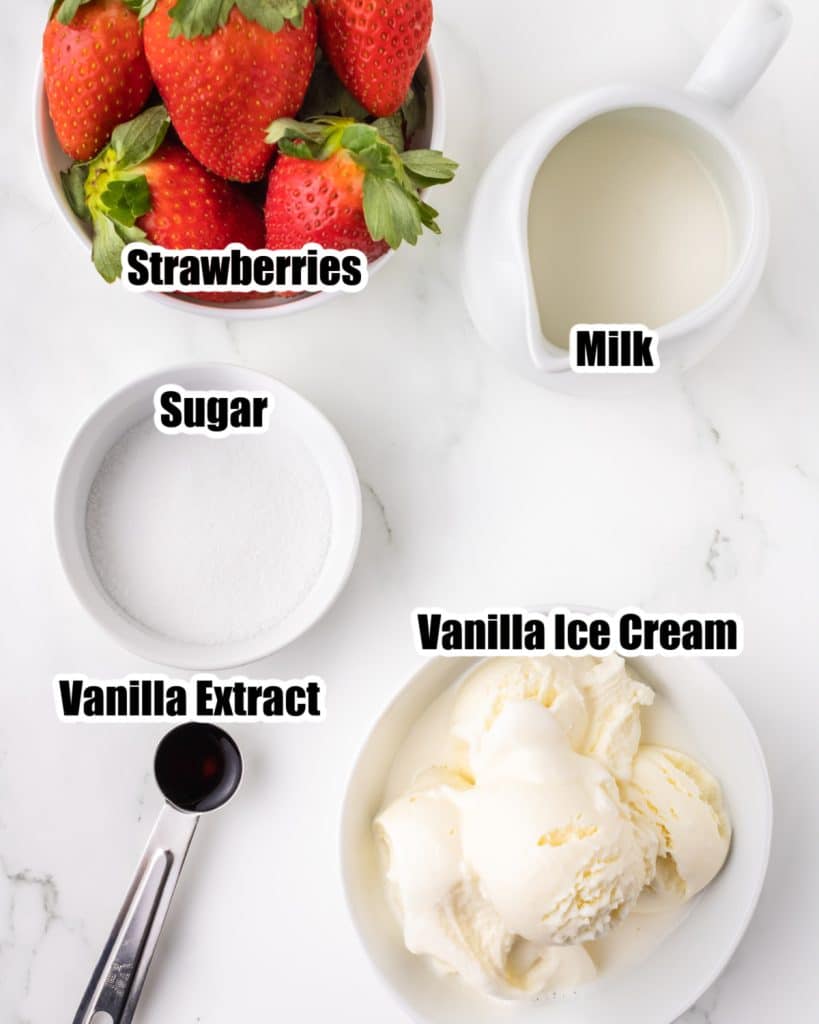 Bowl of strawberries, milk, sugar, and ice cream. 