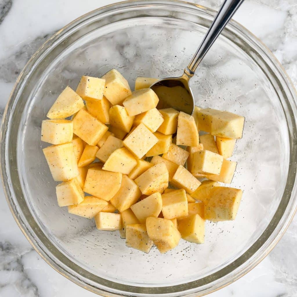 Cubed rutabaga in a bowl with a spoon. 