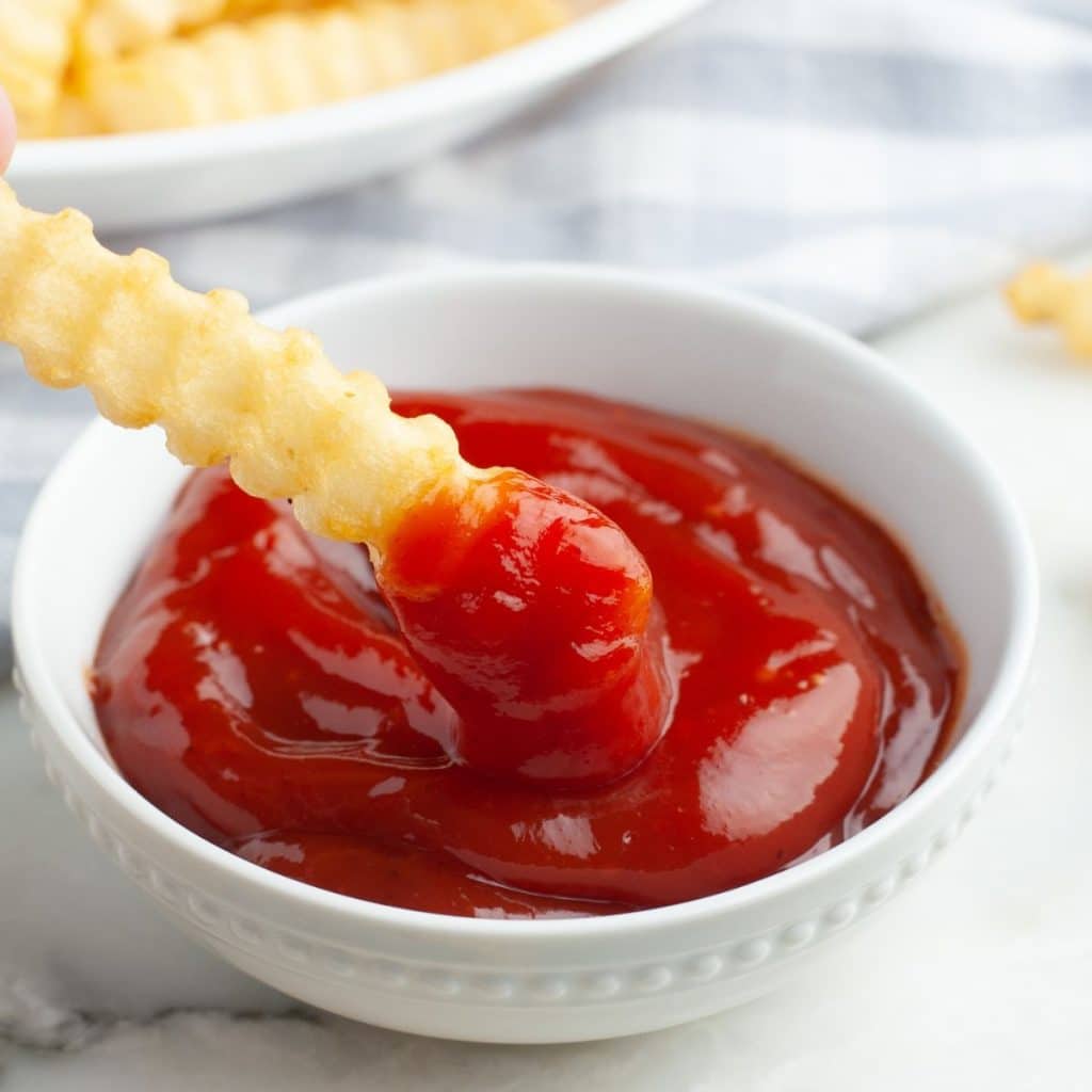 French fry dipping into ketchup.