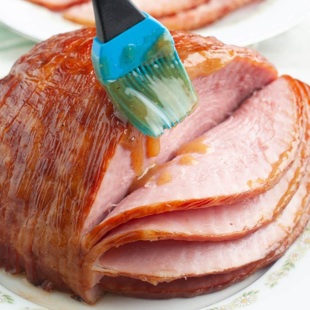 Glaze being added to ham. 
