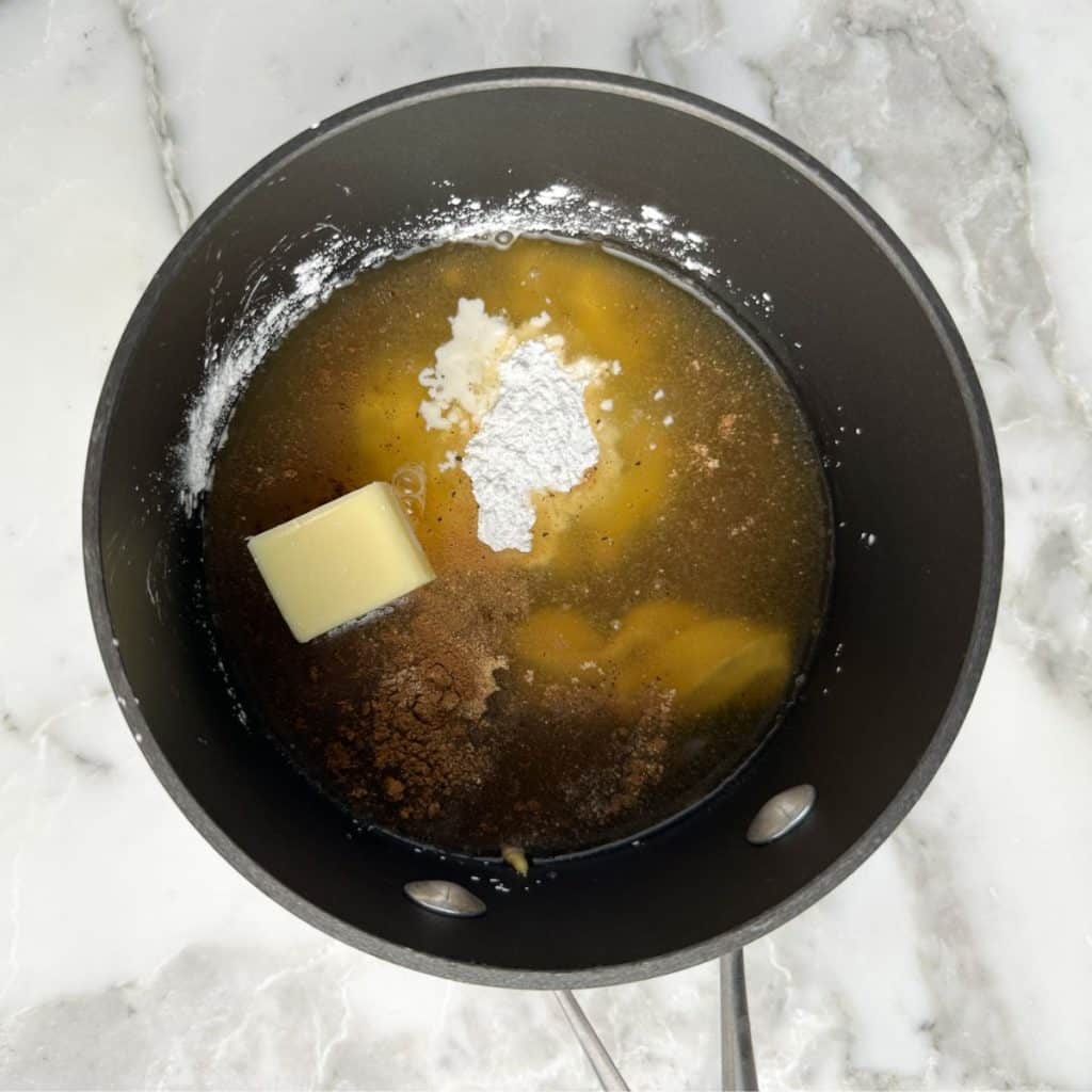 Saucepan with butter, brown sugar, cornstarch, and juice. 