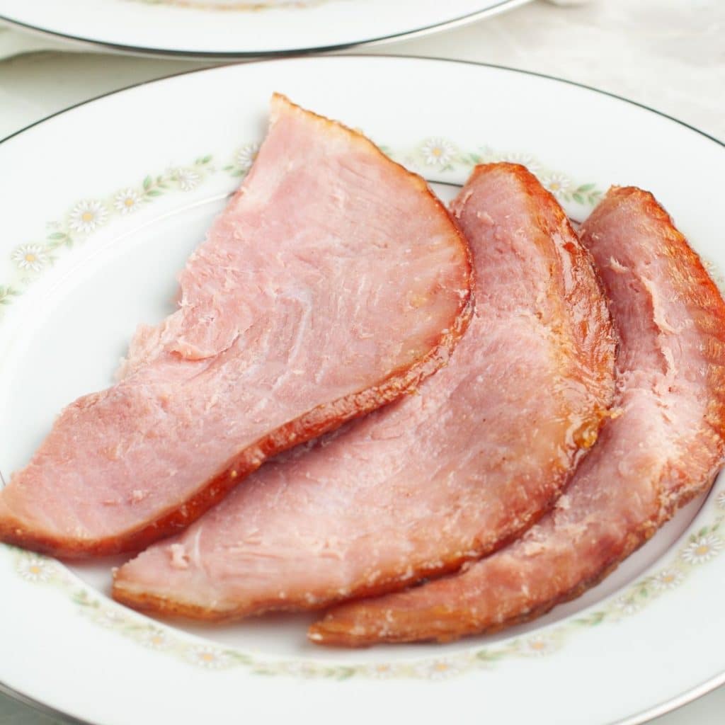 Slices of baked ham on a plate. 
