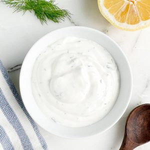 Bowl of dill sauce with a lemon.