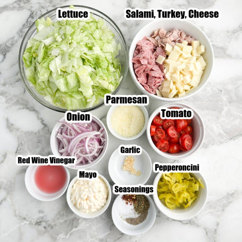 Bowl of lettuce, onion, tomatoes, meat, cheese, and mayonnaise. 