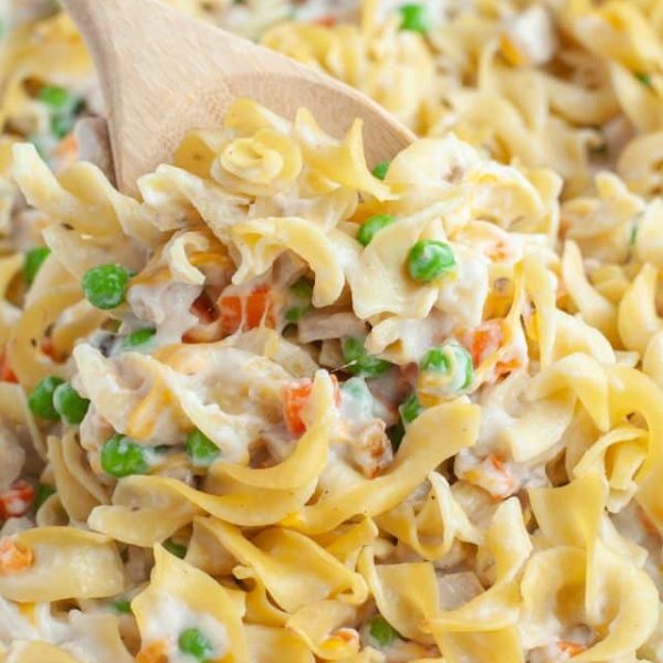 Wooden spoon with egg noodles and vegetables and pork.