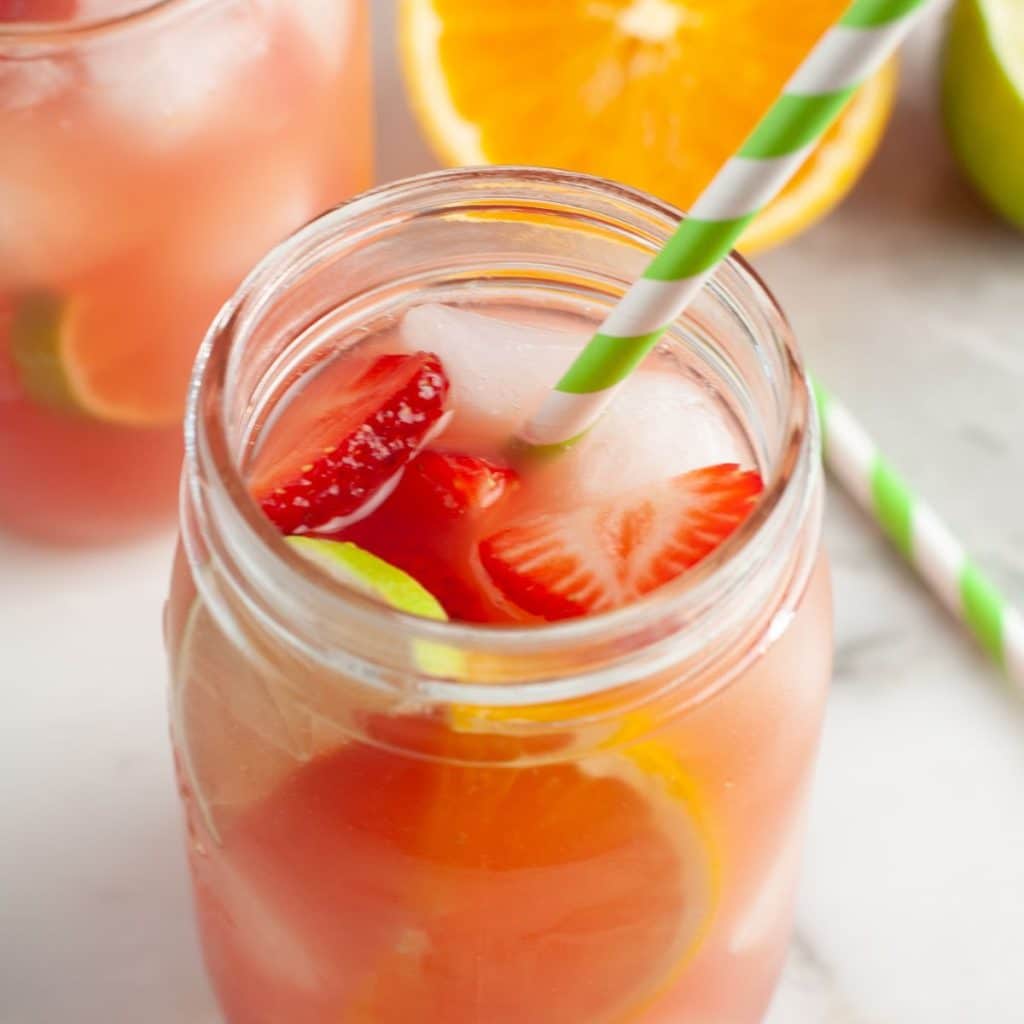 Glass of fruit punch and green straw. 