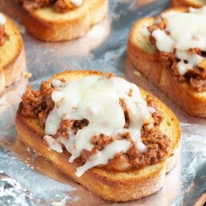 Piece of Texas Toast topped with sloppy joe meat and melted cheese.