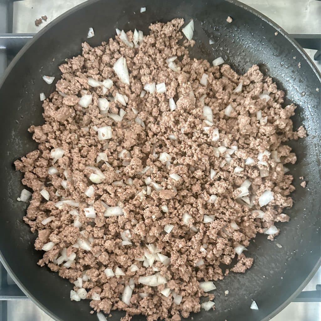 Skillet with cooked ground beef and onion.