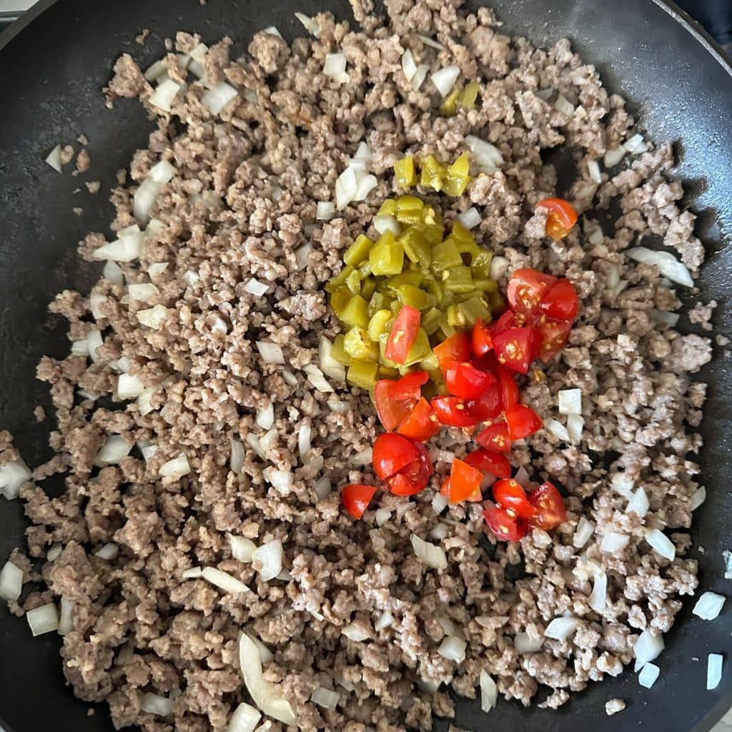 Pan with ground sausage, chilies, and diced tomatoes. 