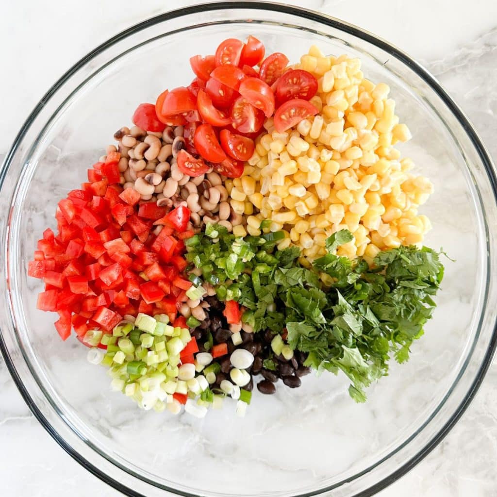 Bowl of chopped pepper, onion, cilantro, corn, and beans. 