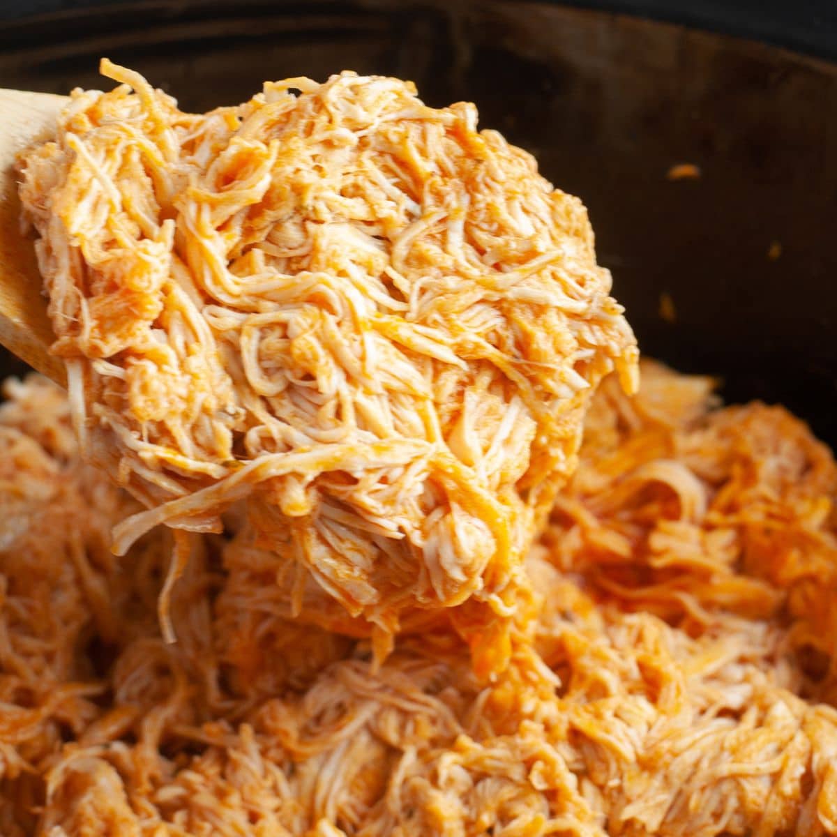 Shredded buffalo chicken in a slow cooker. 