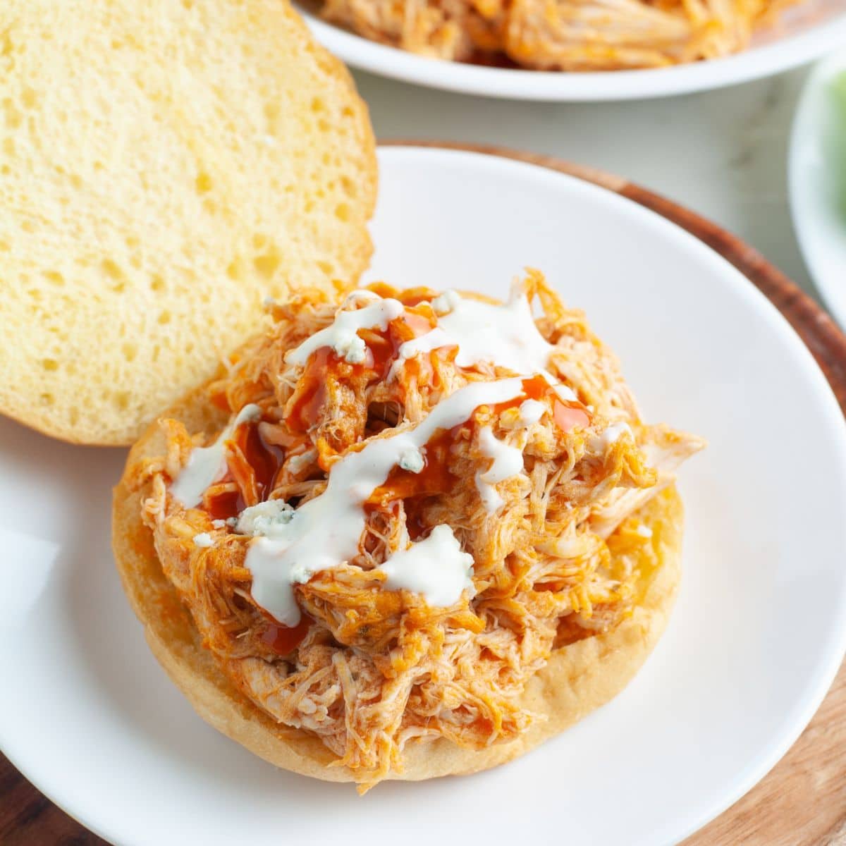 Chicken sandwich topped with buffalo sauce and ranch dressing.