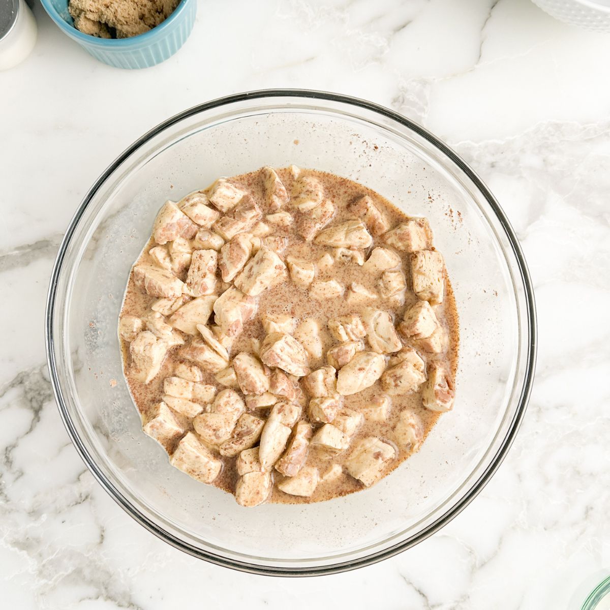 Bowl with cut up cinnamon rolls and egg mixture. 