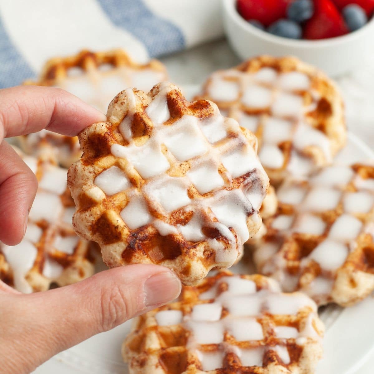 Hand holding a cinnamon roll waffle.