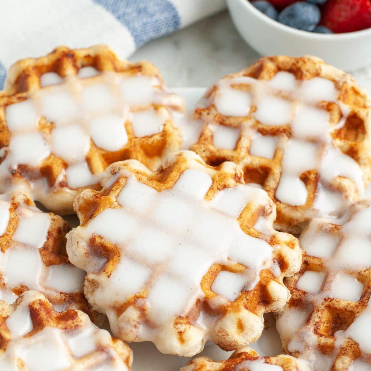 Plate of cinnamon roll waffles with icing. 