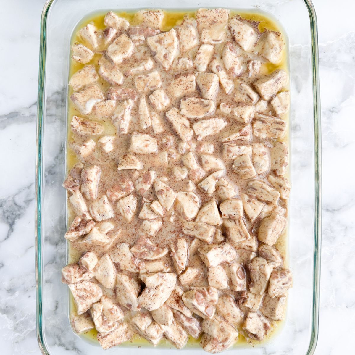 Casserole dish with diced cinnamon rolls and egg mixture. 