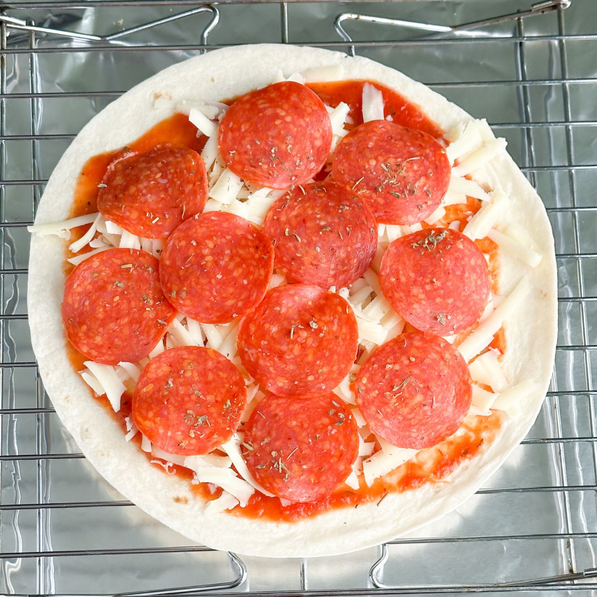 Tortilla topped with cheese and pepperoni. 