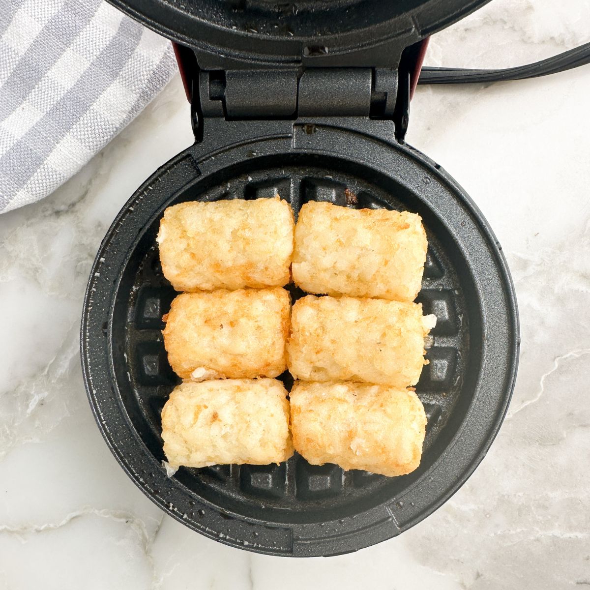 Waffle iron with tater tots.