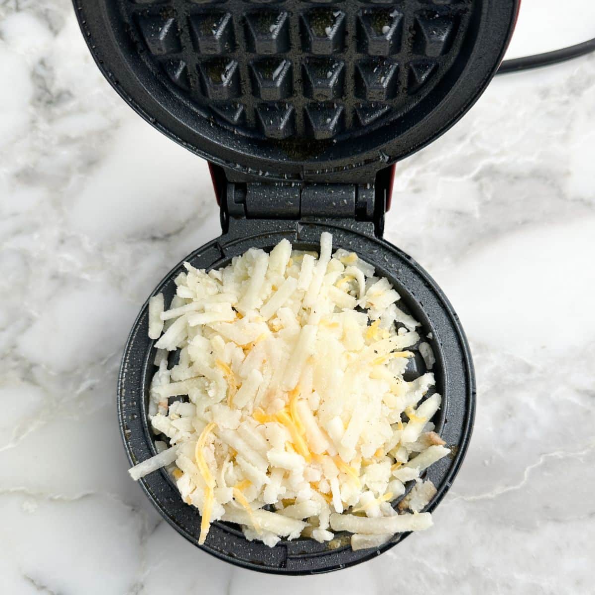 Hash browns on a waffle iron. 