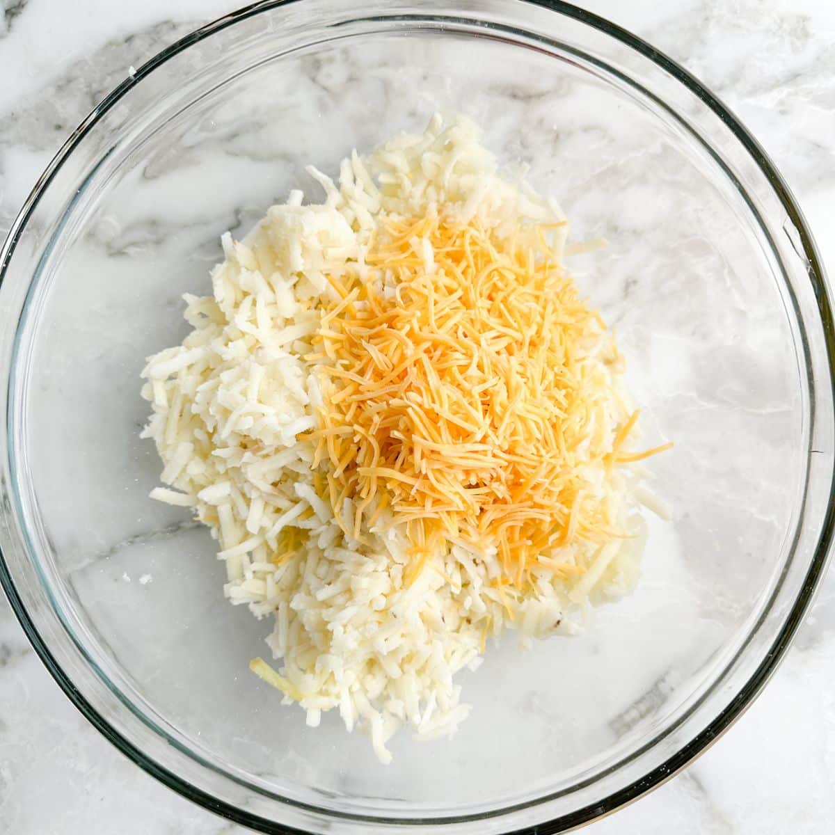 Bowl with hash browns, and shredded cheese.