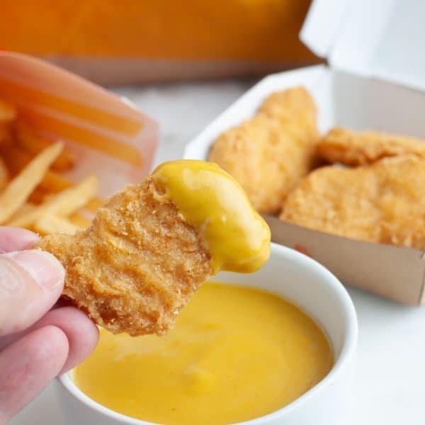 Chicken nugget dipped in mustard sauce.