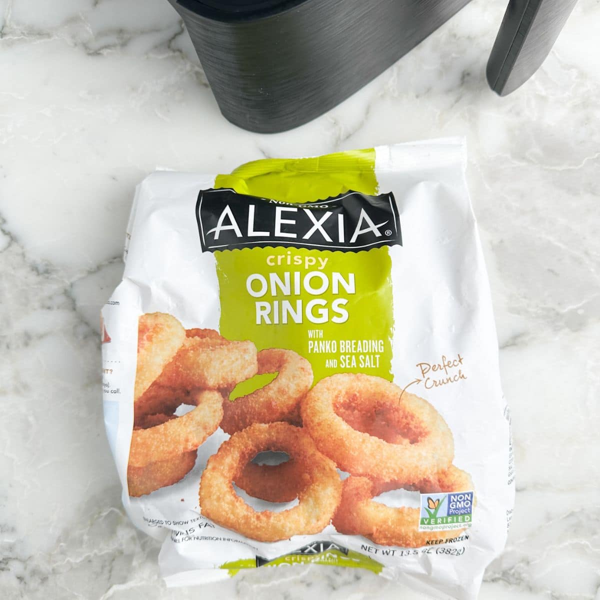 Bag of Alexia onion rings and an air fryer basket. 