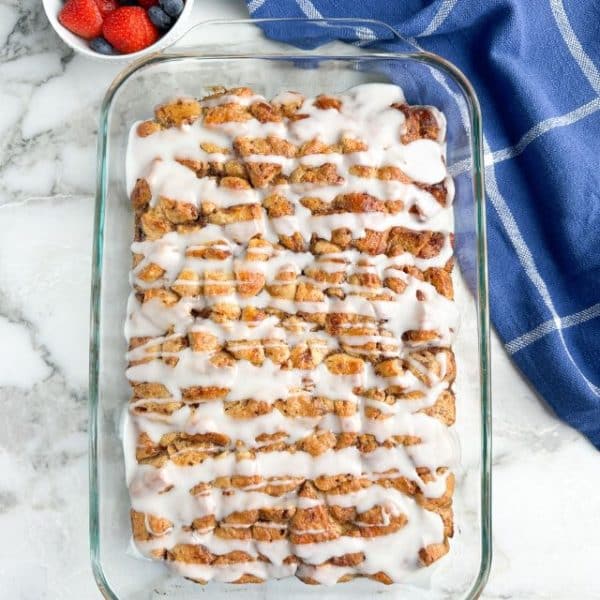 Casserole dish with cinnamon rolls and icing.