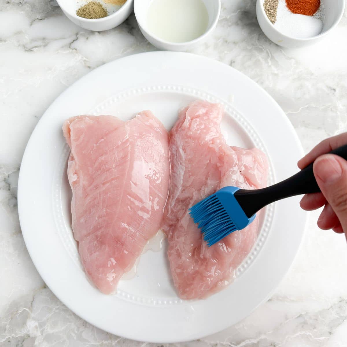 Plate of turkey tenderloin brushed with olive oil. 