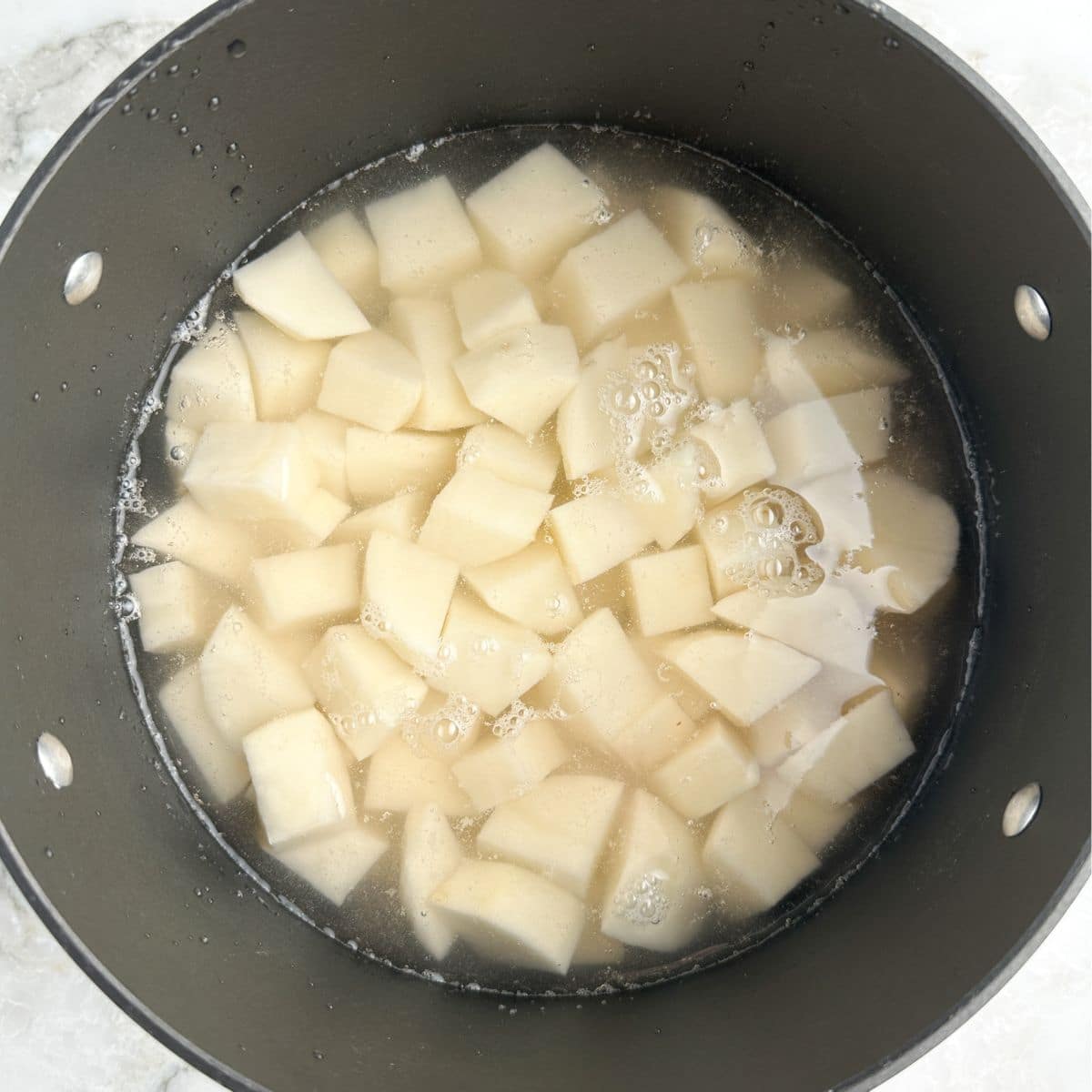 Pot with diced potatoes and water. 