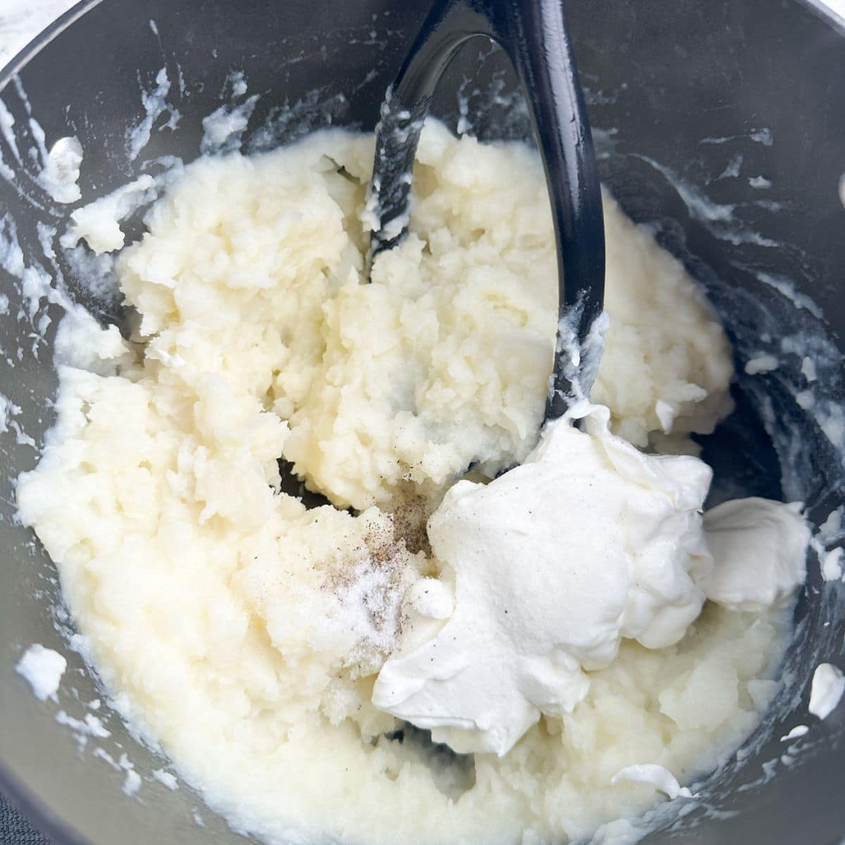 Pot with mashed potatoes and sour cream.