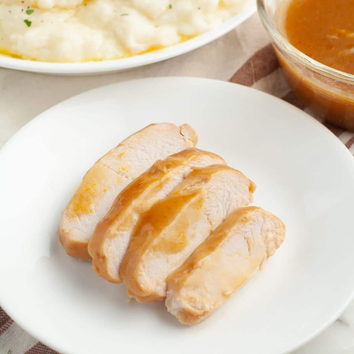 Sliced turkey on a plate with gravy.