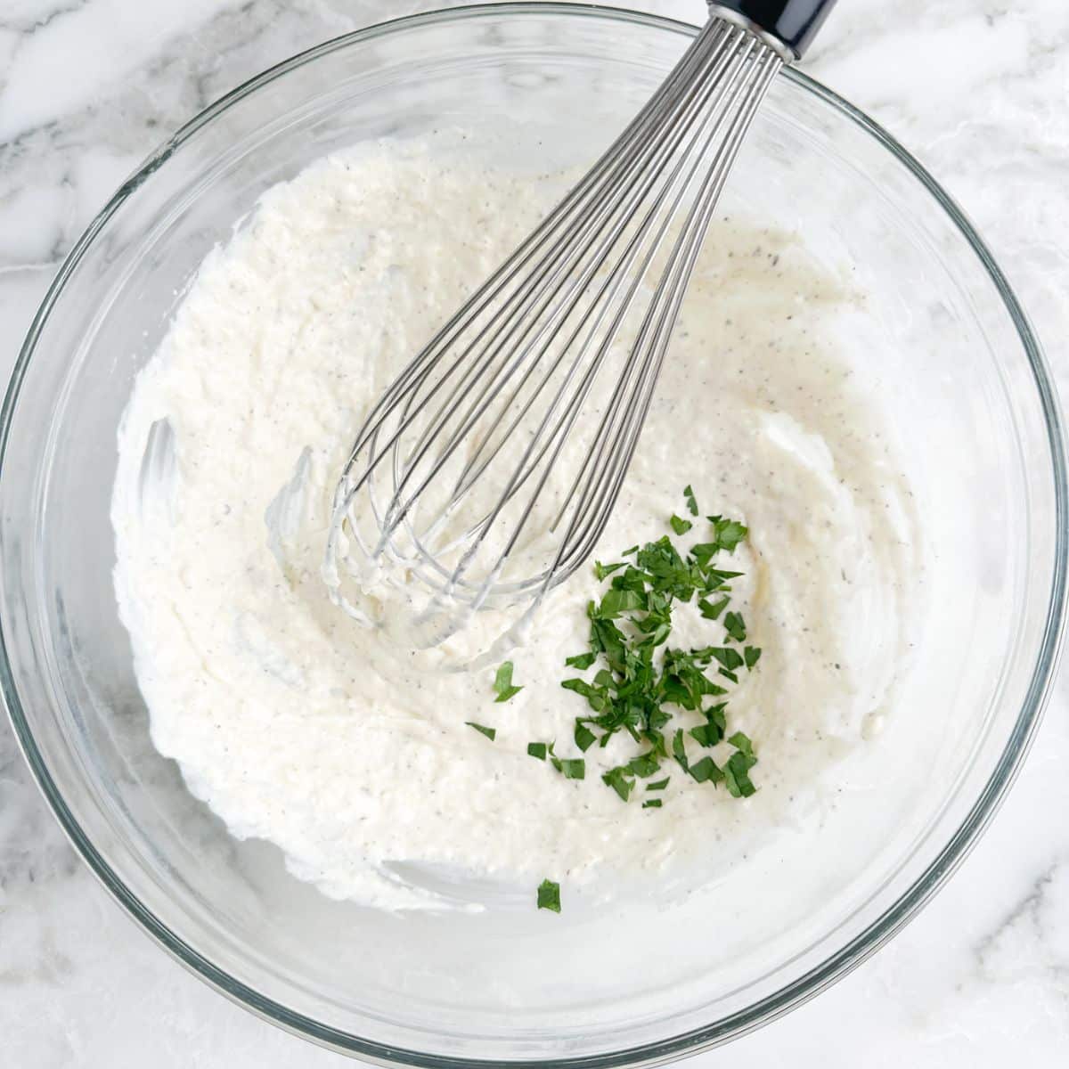 Bowl with creamy sauce and parsley. 