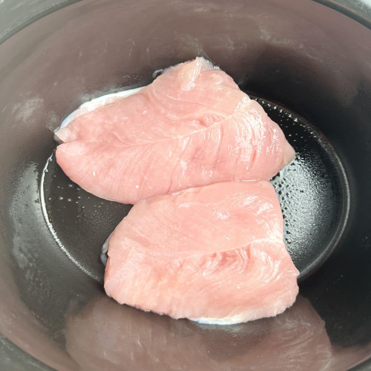 Two turkey tenderloins in a slow cooker. 