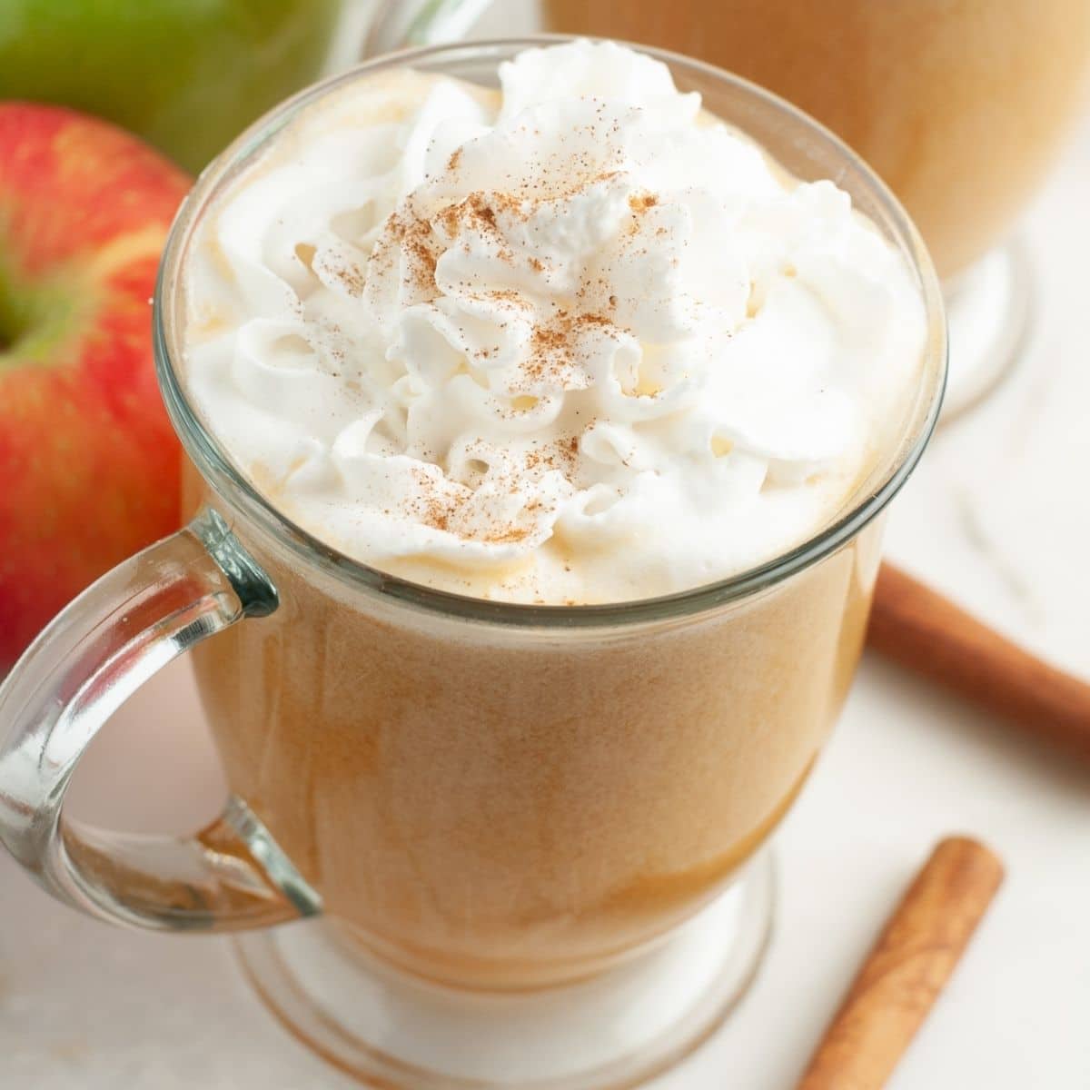 Mug with apple cider and topped with whipped cream. 