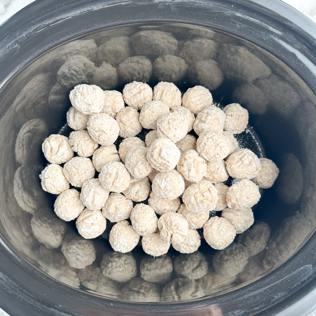 Frozen meatballs in a slow cooker. 