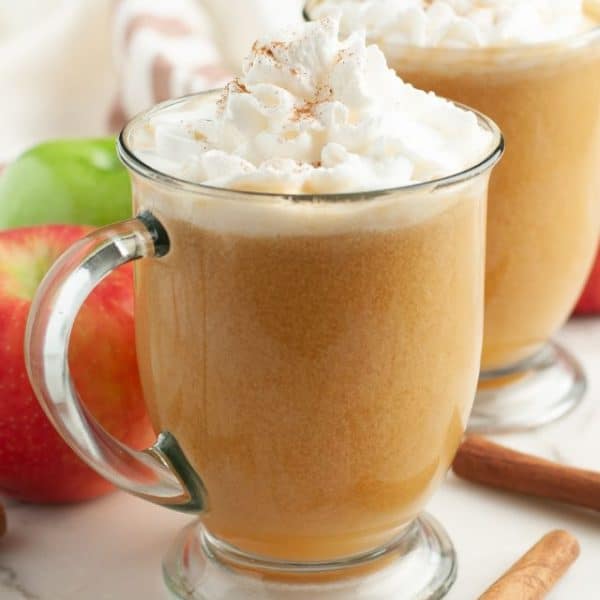 Mug with caramel apple cider and whipped cream.
