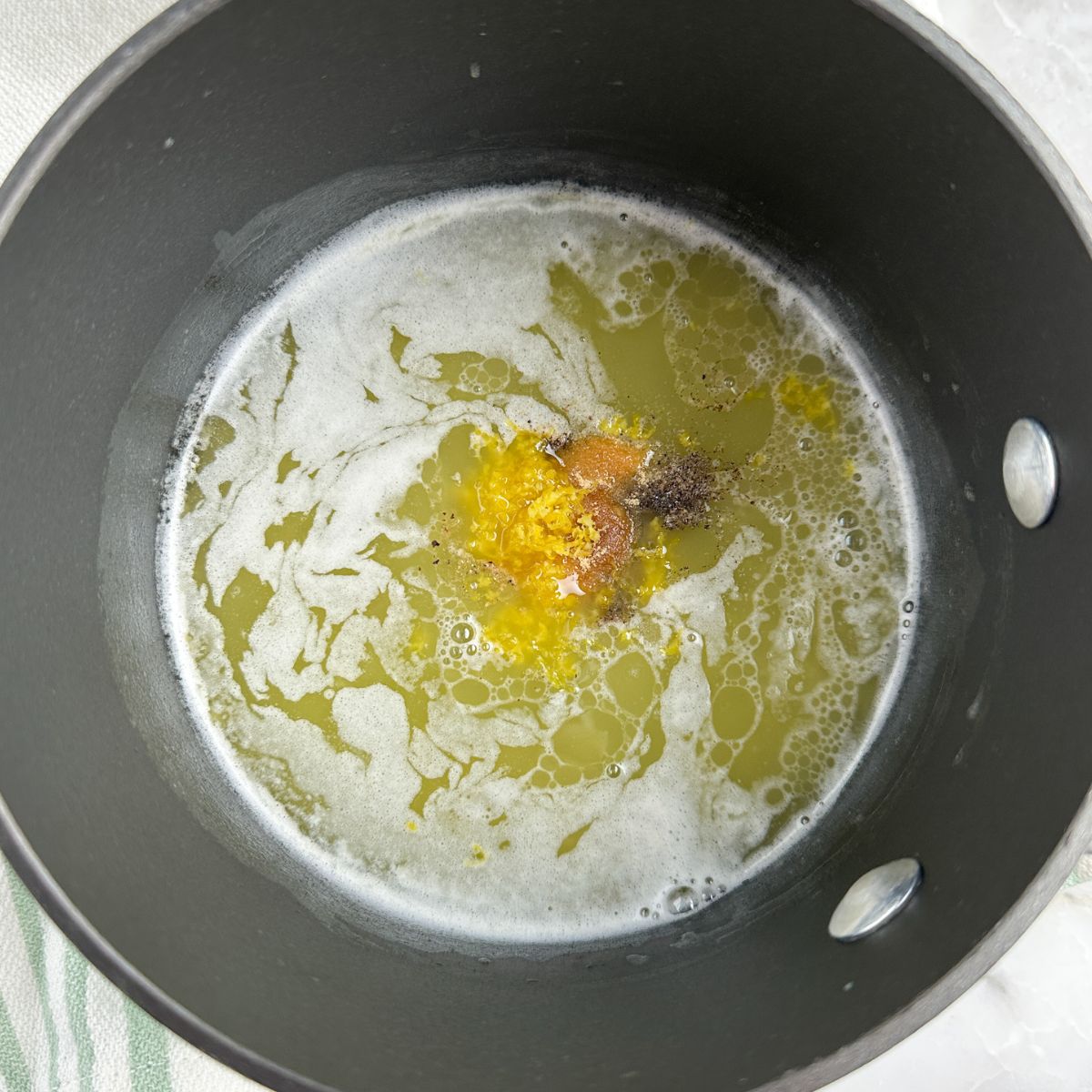 Sauce pan with melted butter, lemon zest, and black pepper. 