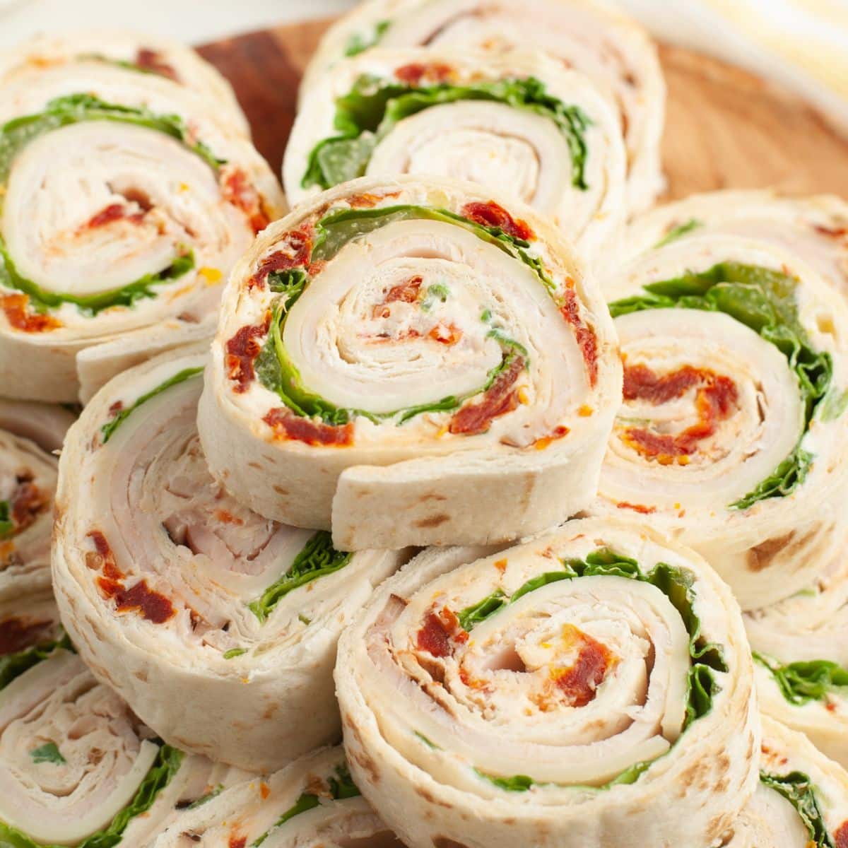 Turkey roll ups stacked on a plate. 