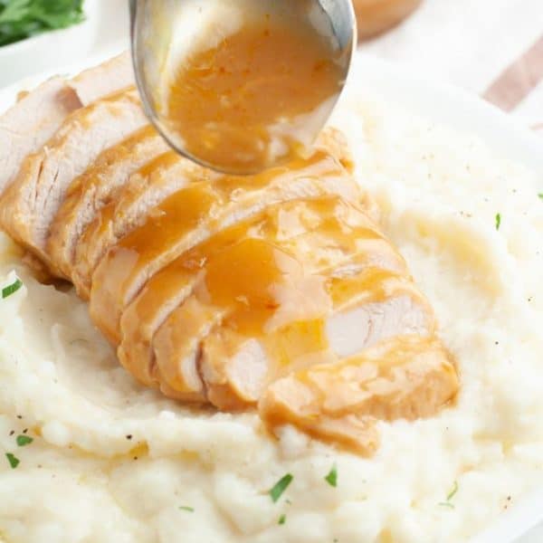 Sliced turkey over mashed potatoes.