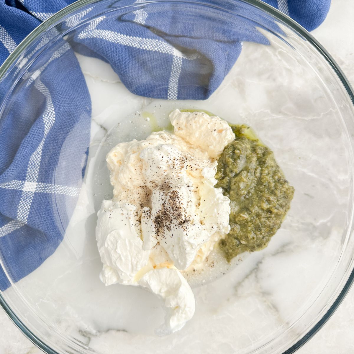 Bowl with mayonnaise, sour cream, and pesto. 