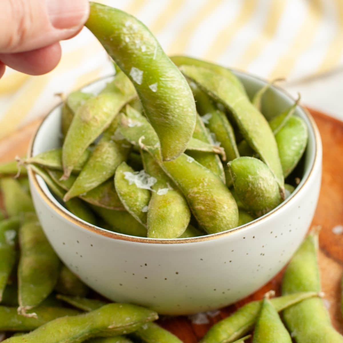 Hand holding edamame. 