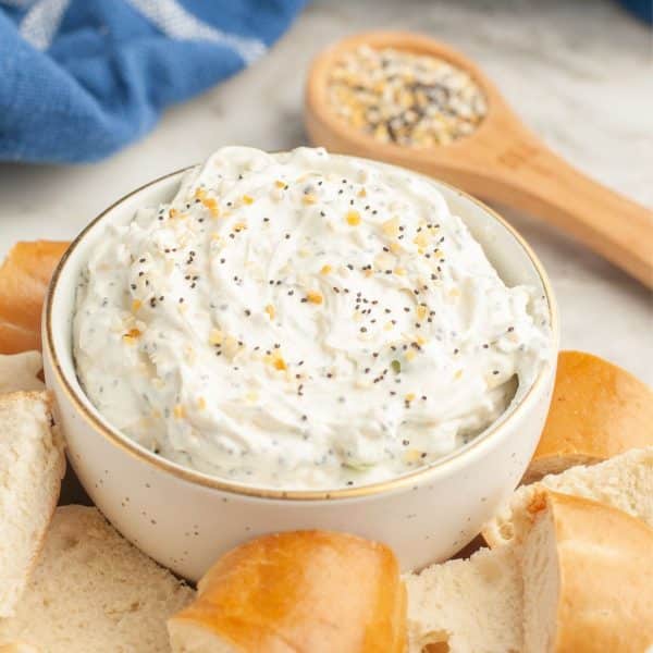 Bowl of everything bagel dip with cut up bagels.
