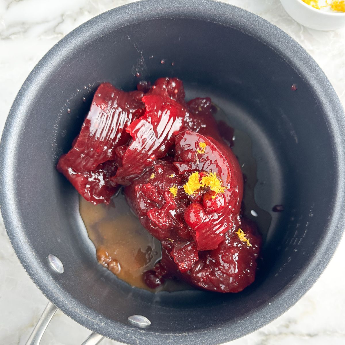 Pot with canned cranberry sauce, orange juice, and orange zest. 