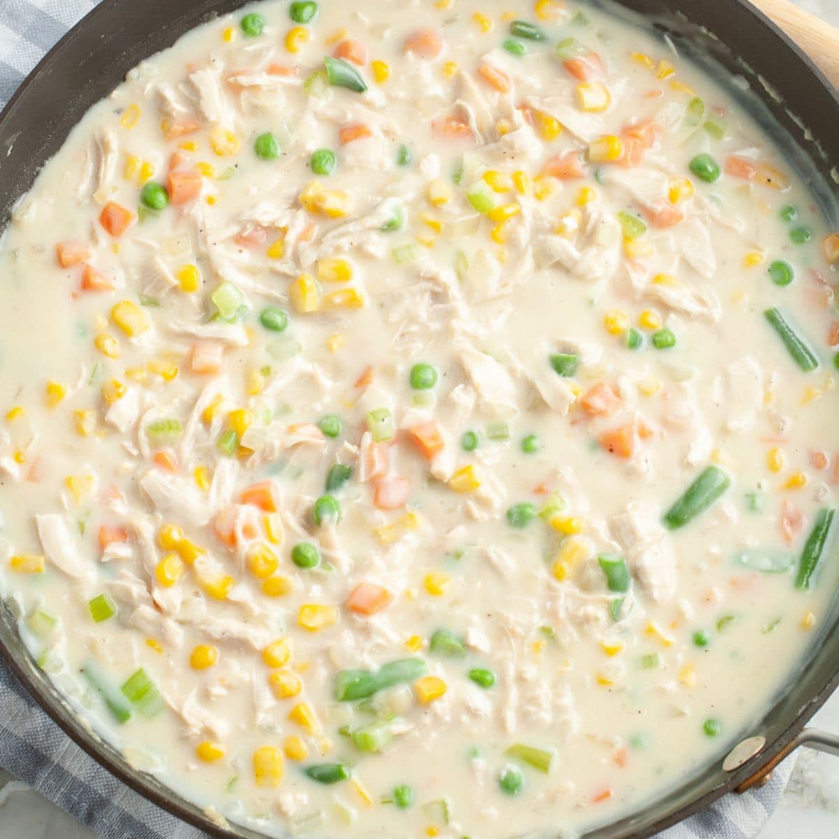 Skillet with chicken pot pie filling.