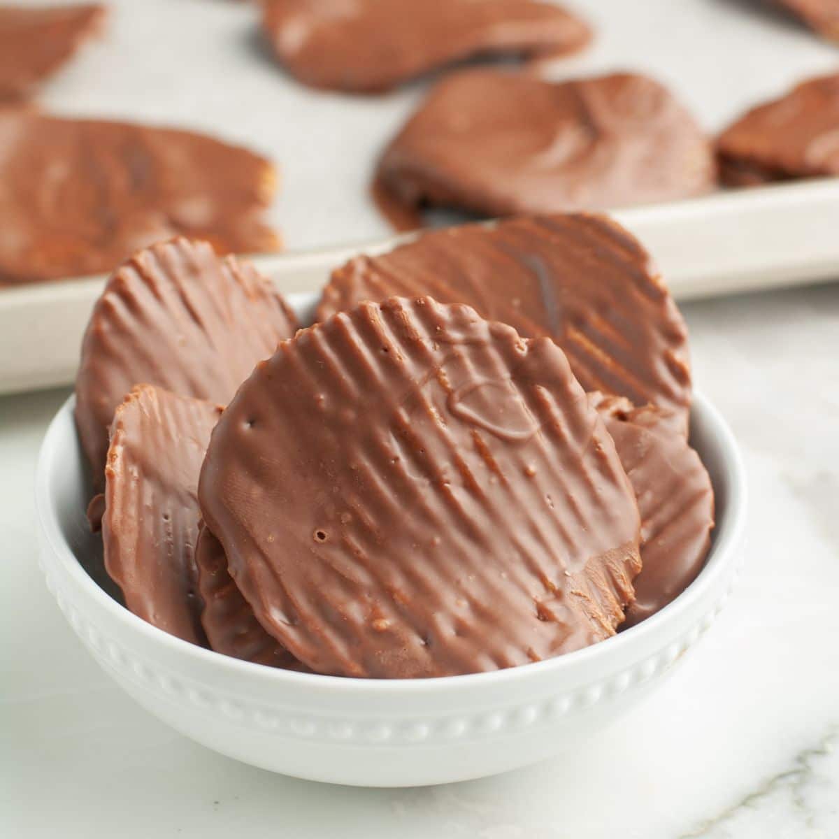 Chocolate covered potato chips in a bowl. 