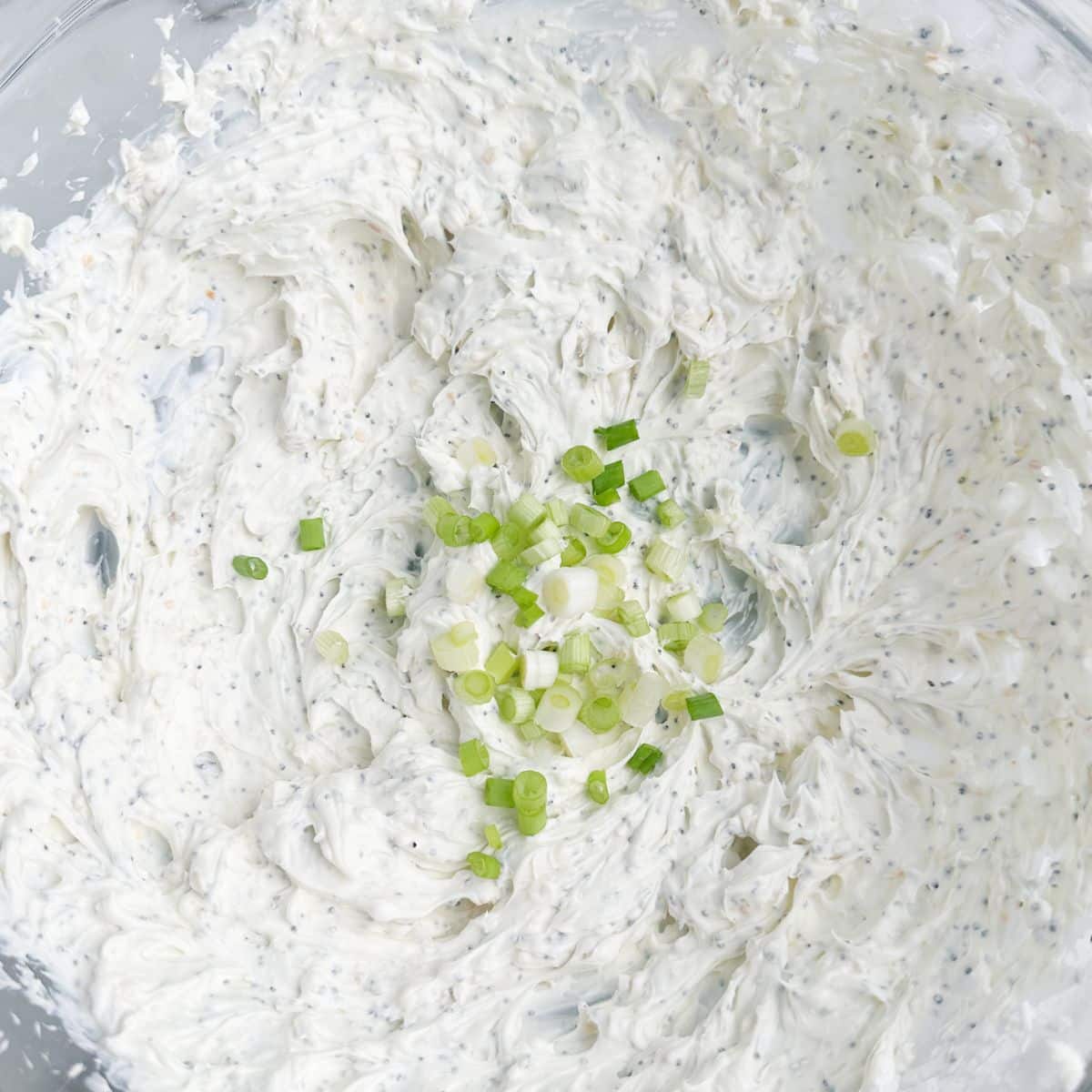 Bowl with whipped cream cheese and diced onion. 